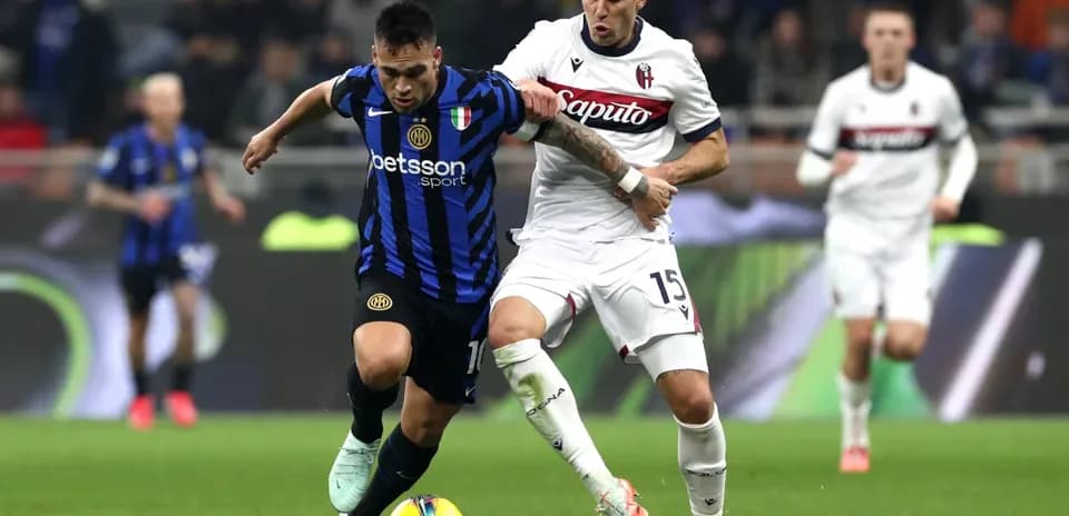 Inter player battling Bologna defender for the ball