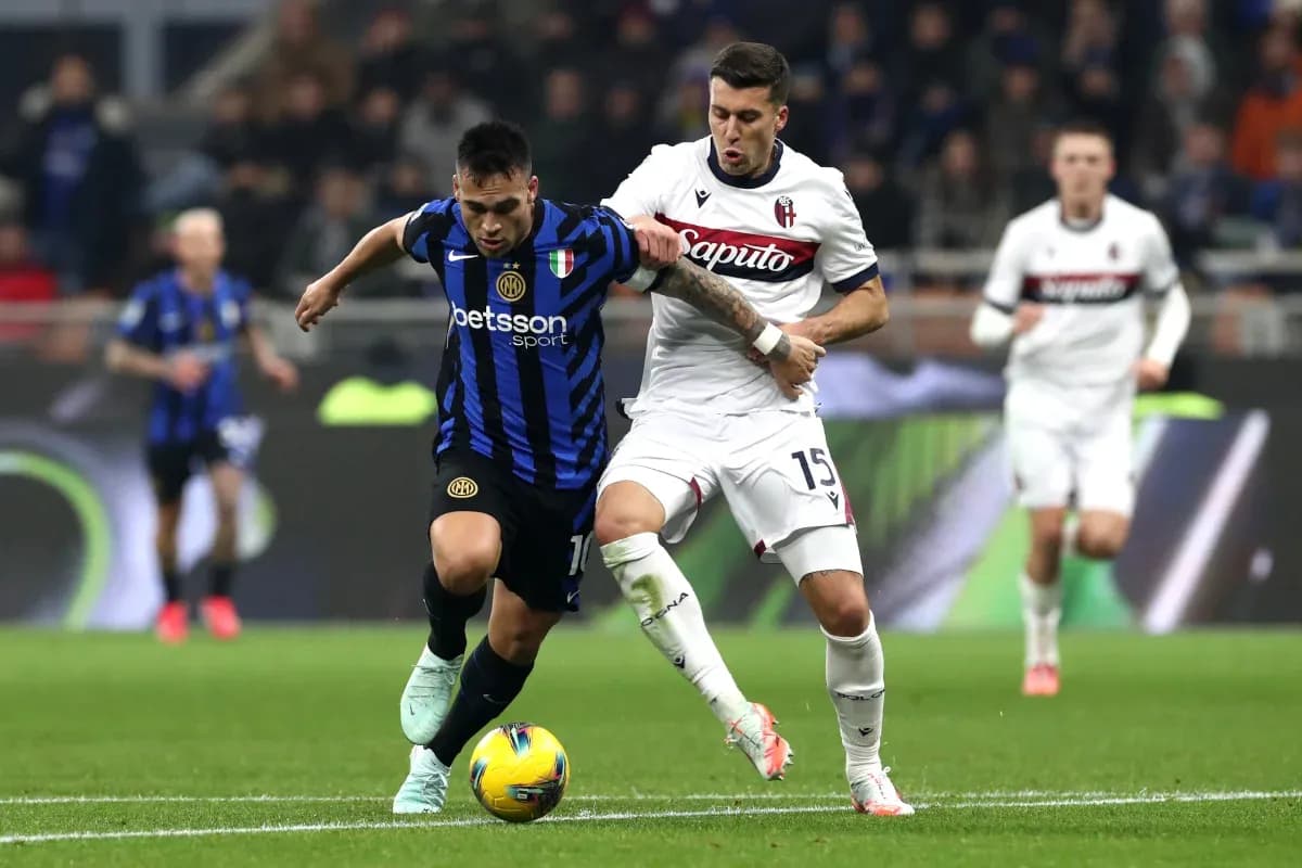 Inter player battling Bologna defender for the ball