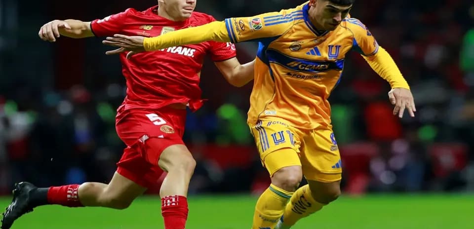 Toluca player challenging Tigres UANL player