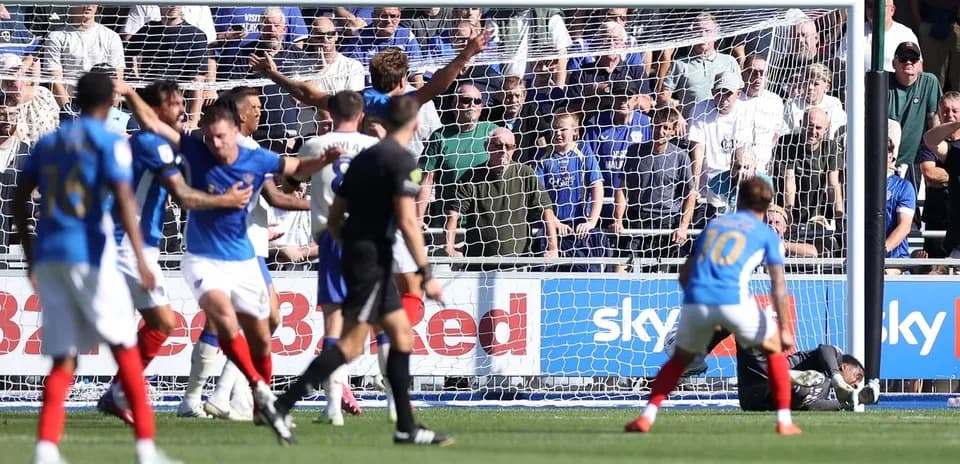 Players reacting during a goal attempt in football match