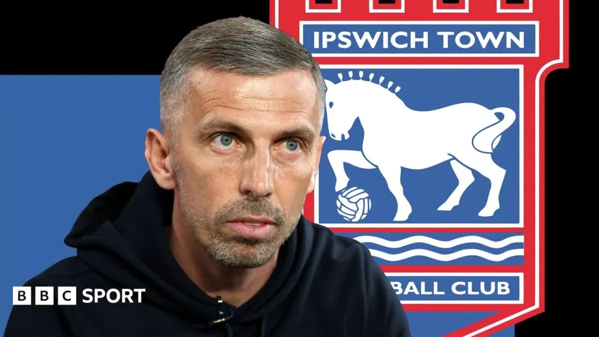 Coach speaking with Ipswich Town logo in background