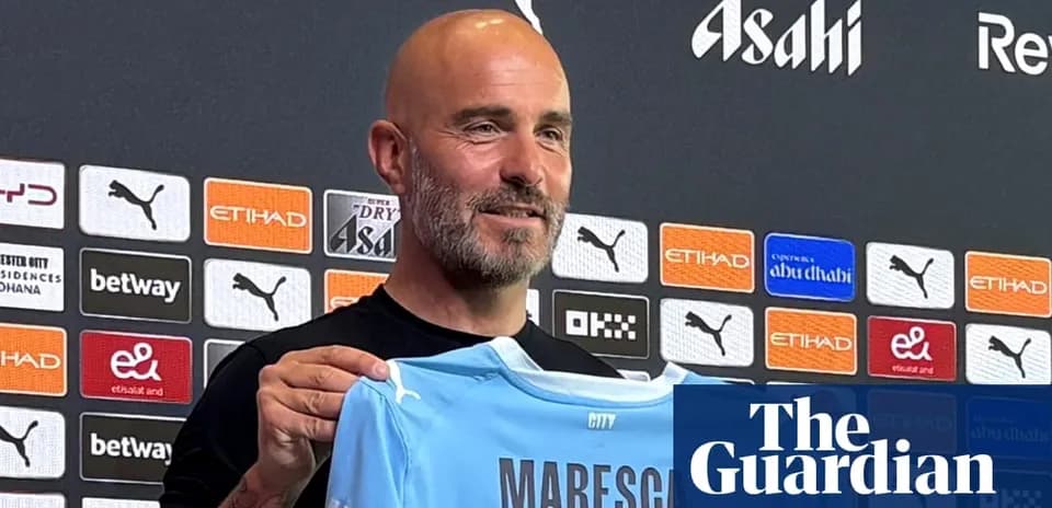 Manager holding Maresca jersey at press conference