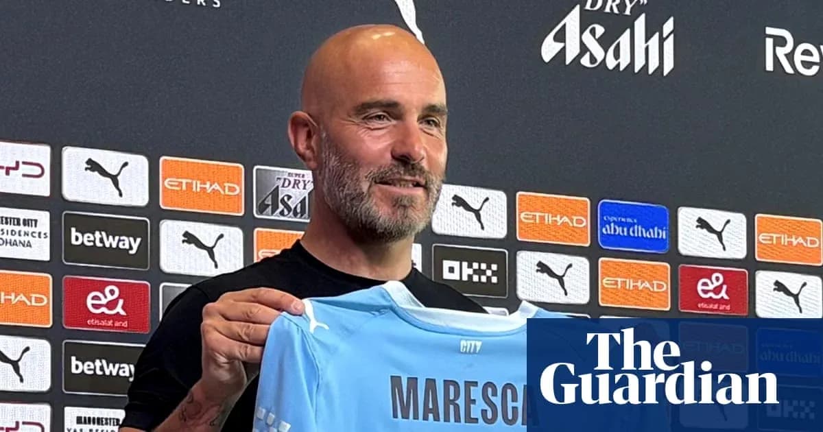 Manager holding Maresca jersey at press conference