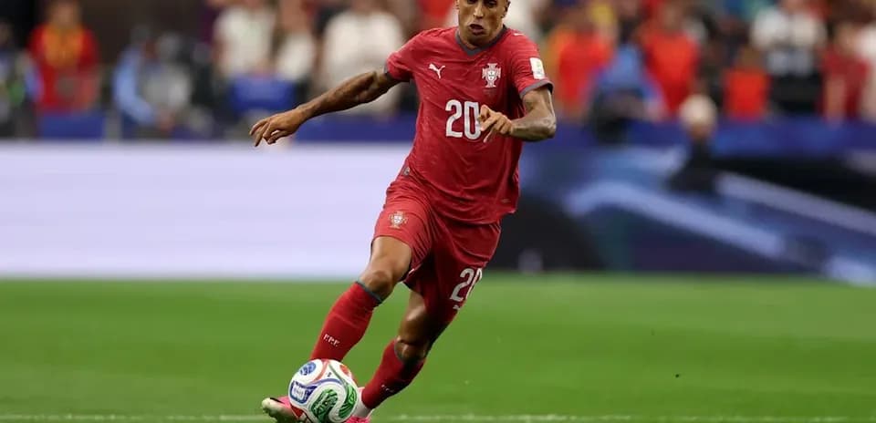 Player in red jersey dribbling the ball on field