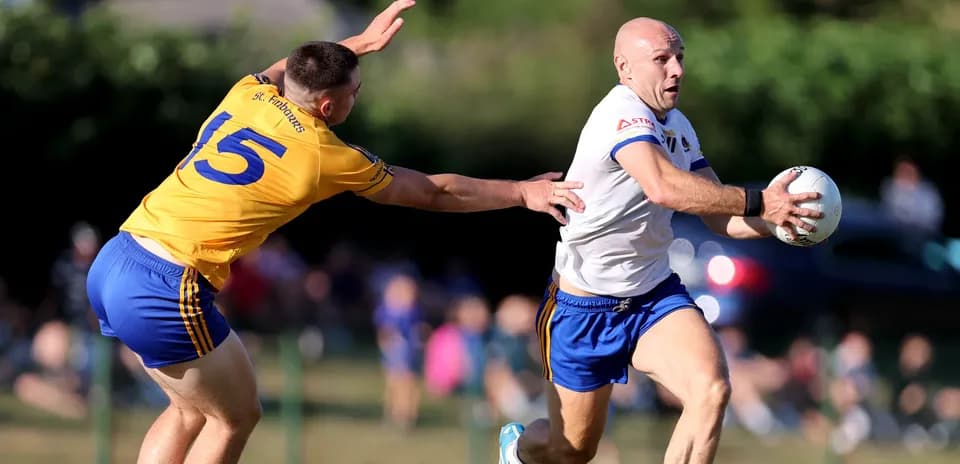 Player in white running with ball, opponent reaching out