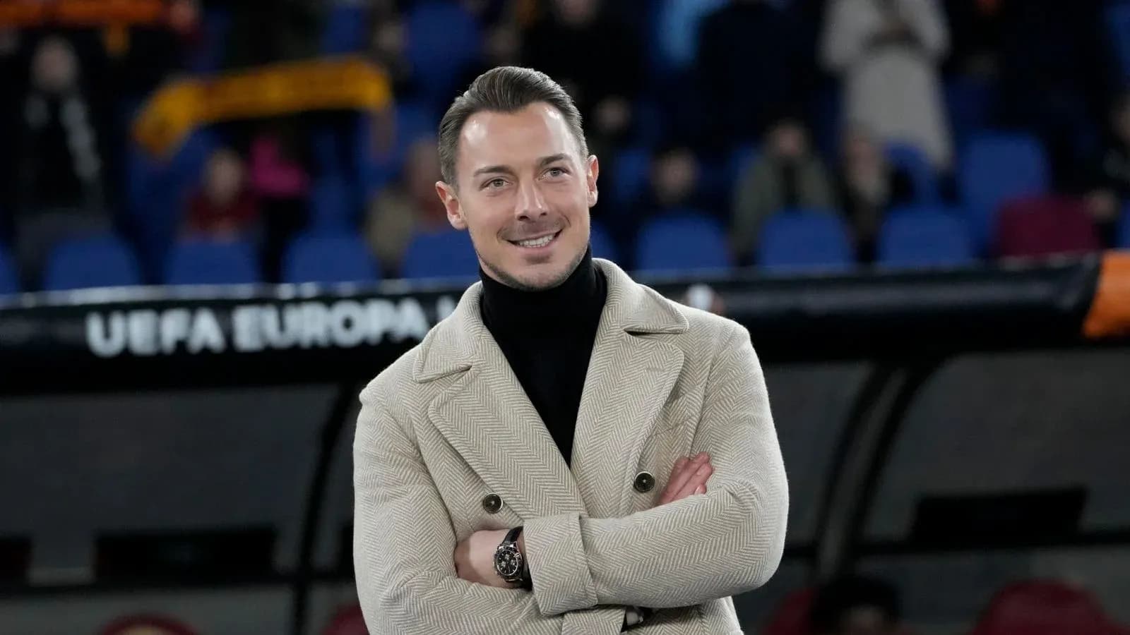 Man in stylish coat standing on the sidelines
