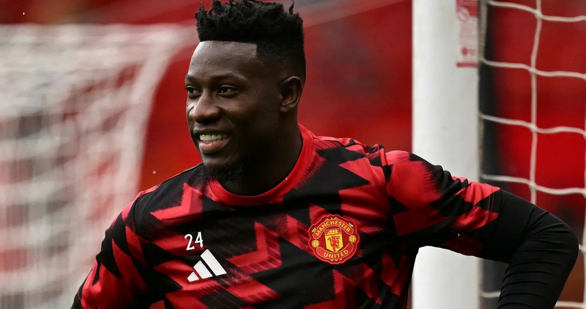 Goalkeeper in Manchester United training kit smiling