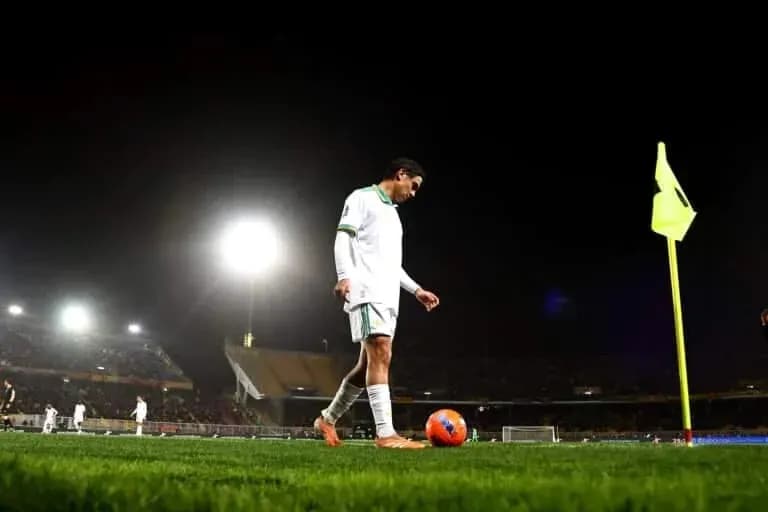 Player preparing to take a corner kick at night
