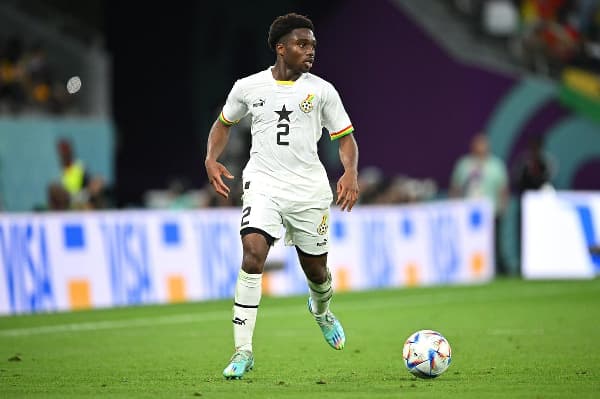 Player in white kit dribbling ball on field