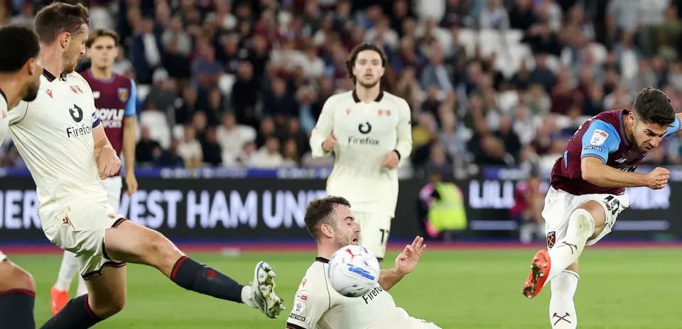 Player kicking ball while opponent falls during match