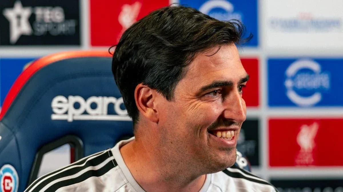 Coach smiling during press conference at podium