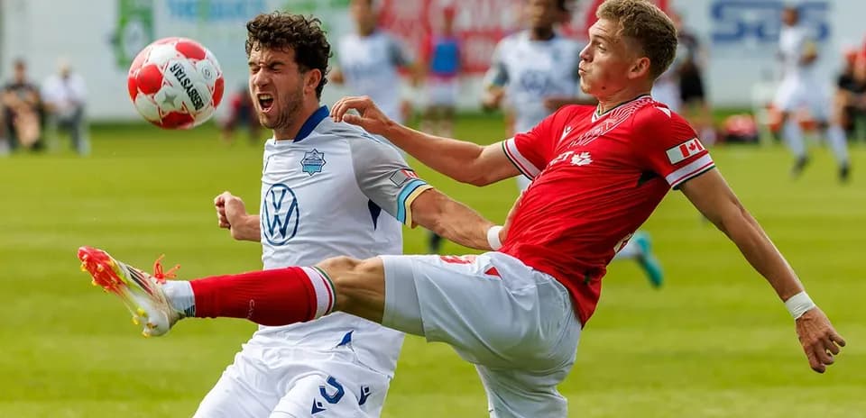 HFX Wanderers FC player tackling Cavalry FC player