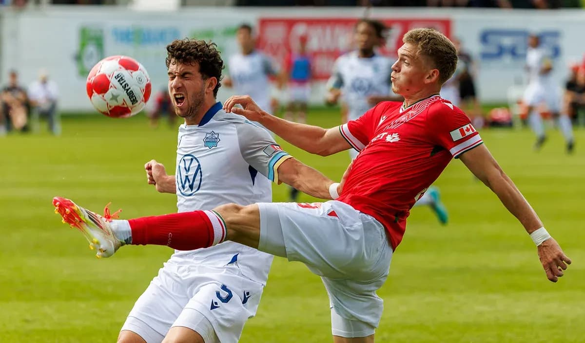 HFX Wanderers FC player tackling Cavalry FC player