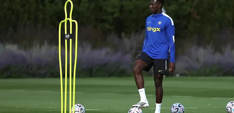 Player training beside a dummy and soccer balls