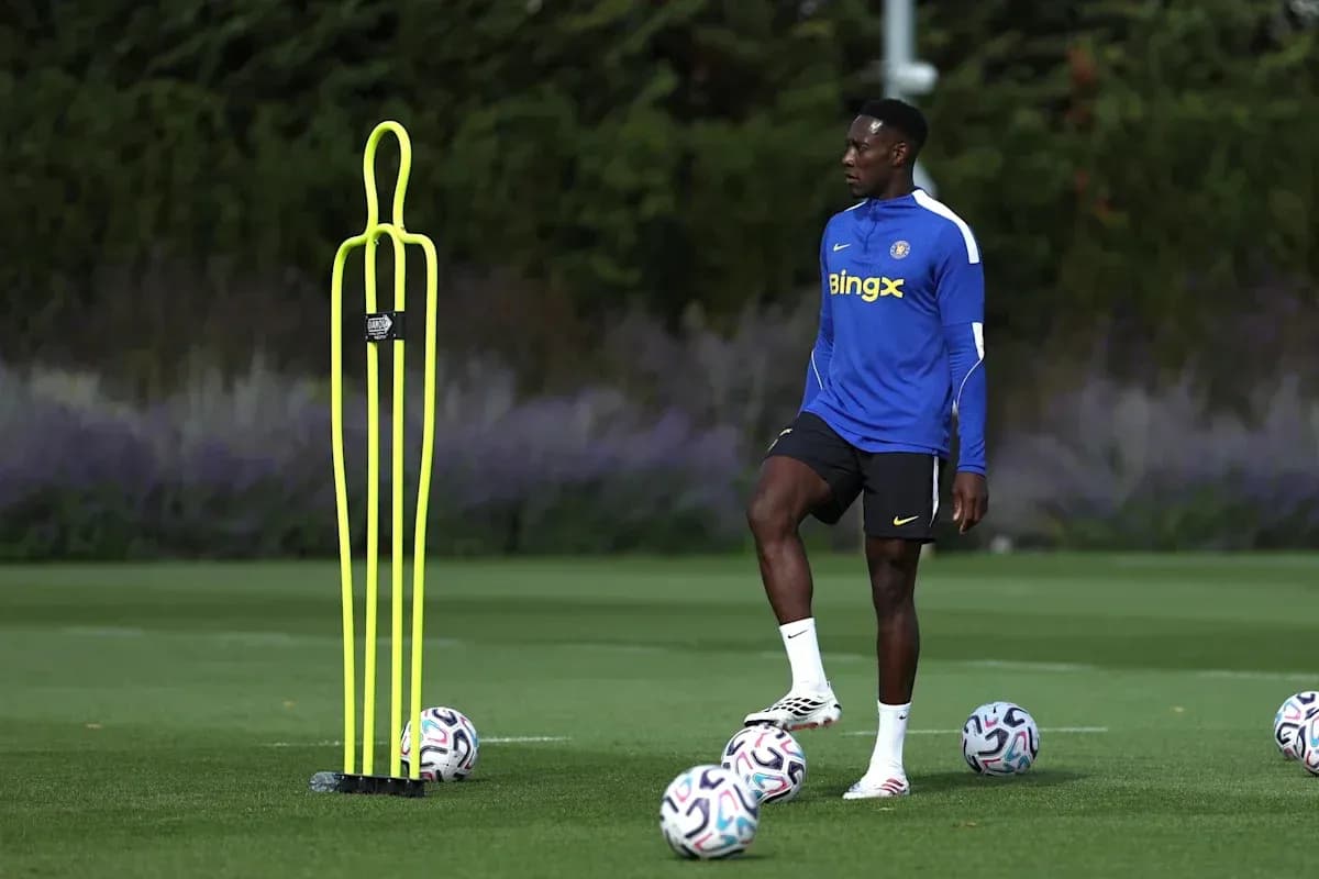 Player training beside a dummy and soccer balls