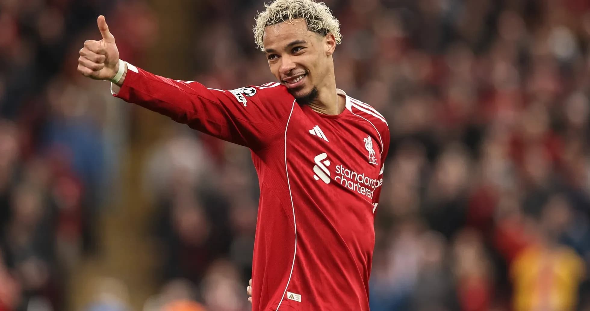 Player celebrating with thumbs up in Liverpool jersey