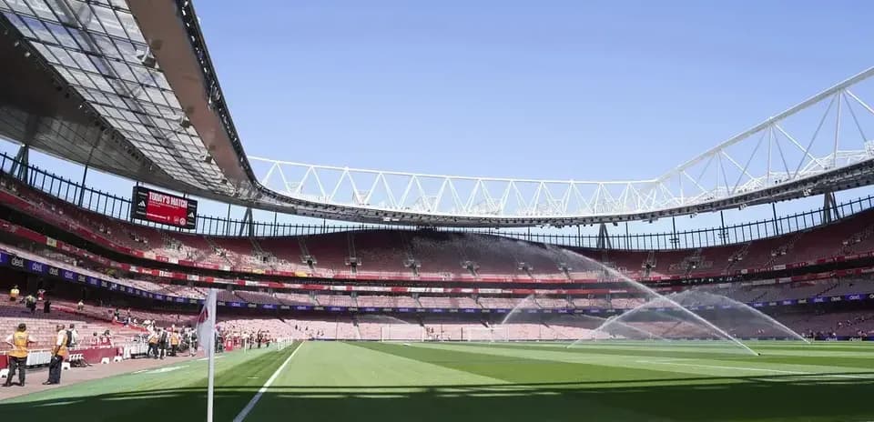 Interior of stadium with sprinklers on the pitch