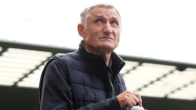 Man in a vest looking upwards at stadium