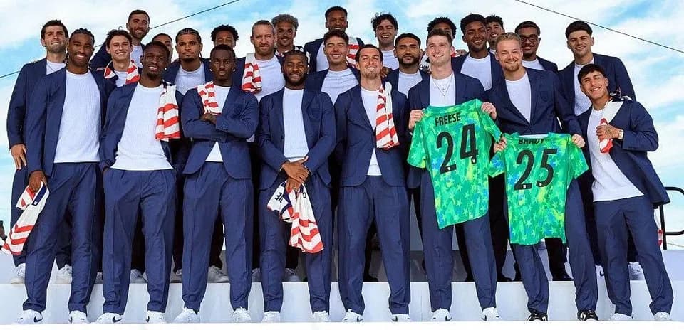 Team posing in suits with jerseys at event