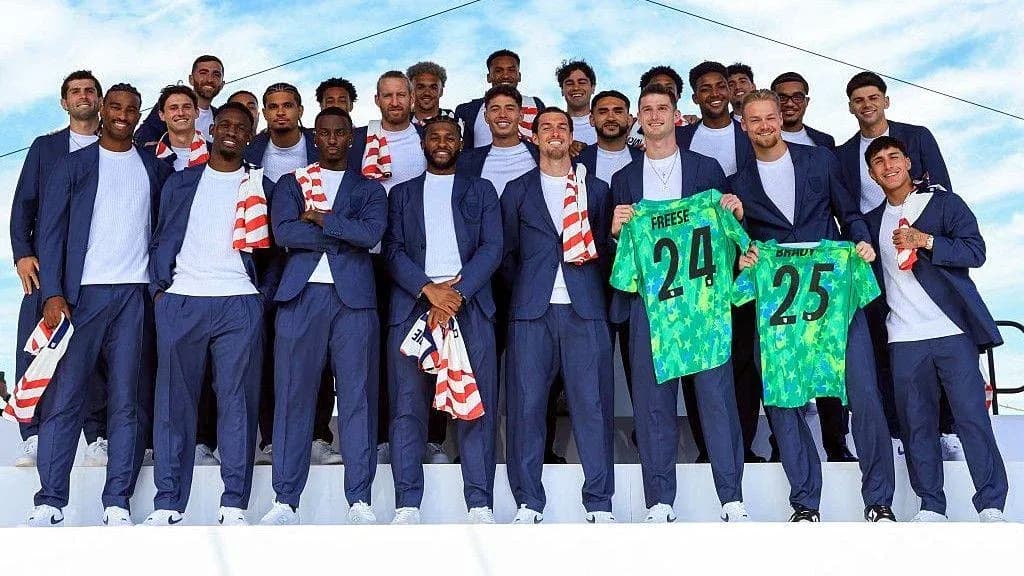 Team posing in suits with jerseys at event