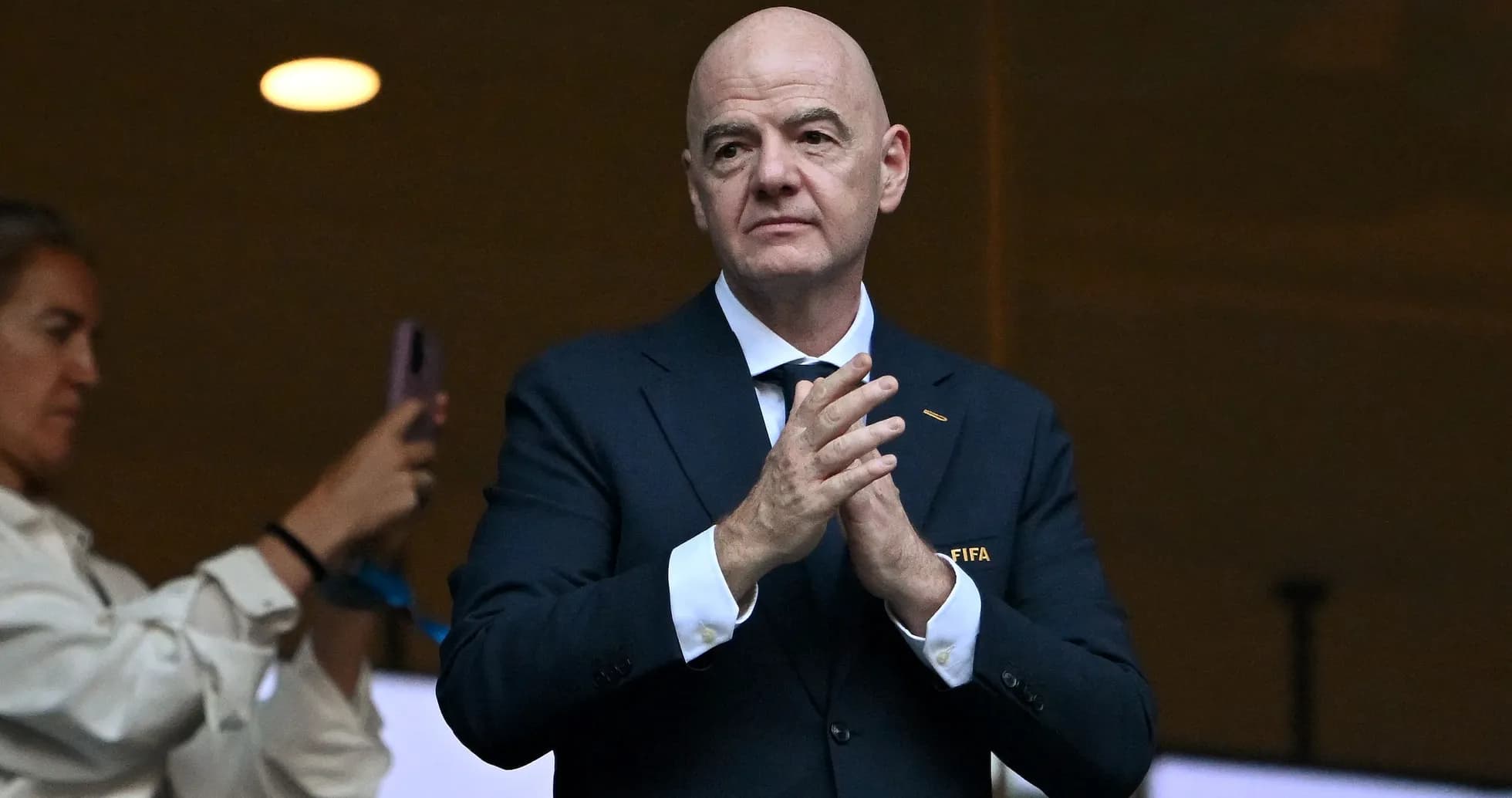 FIFA official clapping in stadium box