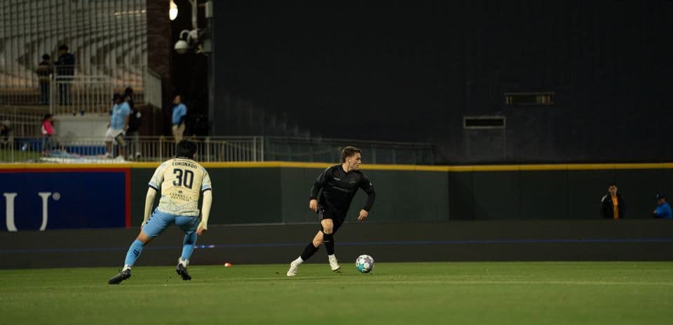 Player dribbling ball during Colorado Springs match