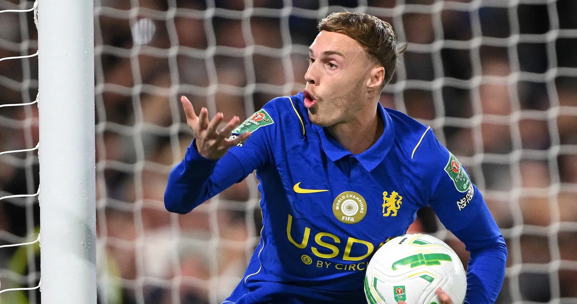 Player gesturing during match, holding soccer ball