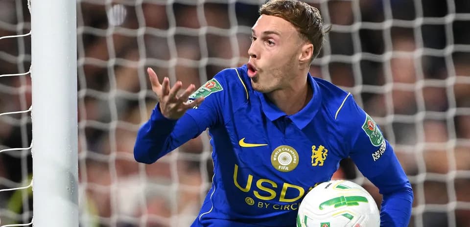 Player gesturing during match, holding soccer ball