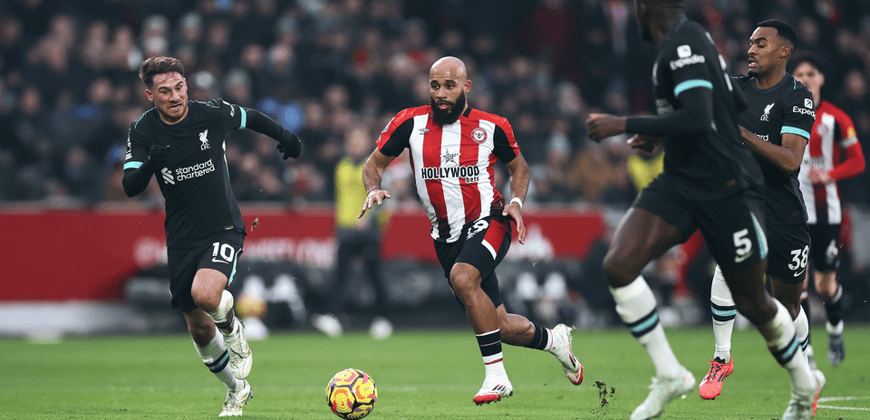 Liverpool player chasing Brentford opponent with ball