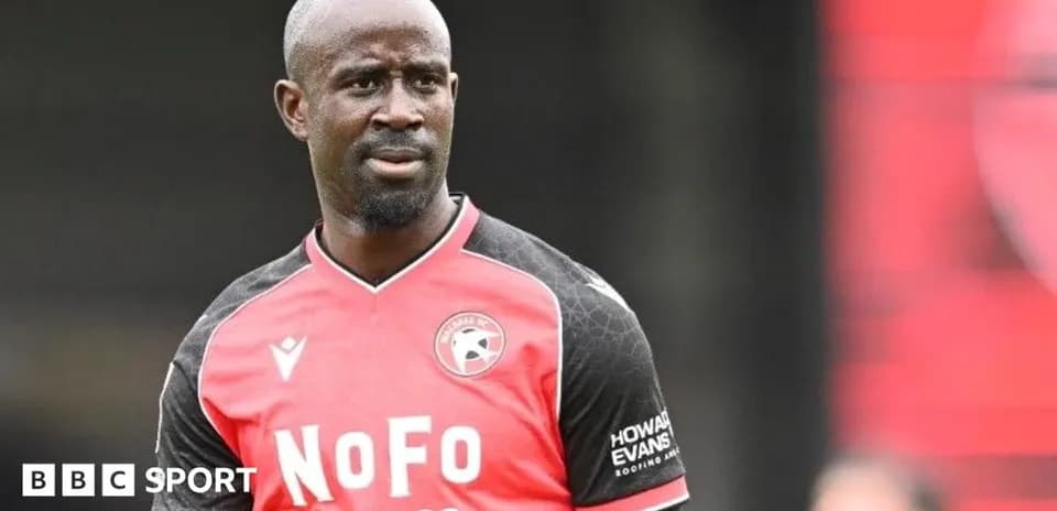 Player in red and black kit on the field