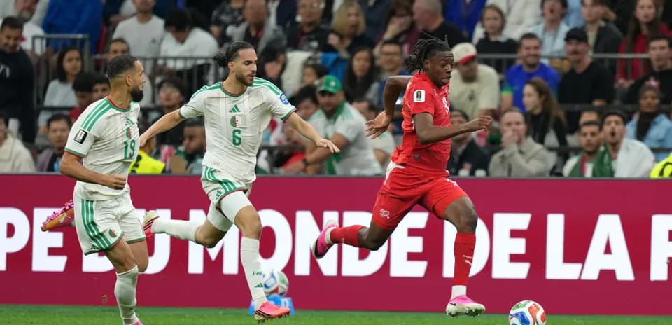 Switzerland player dribbling past Algeria defenders
