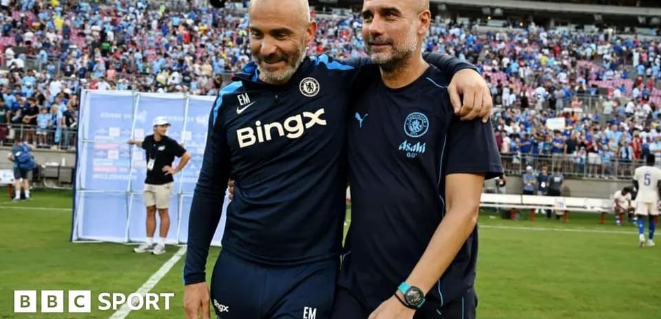 Two coaches embracing on the pitch after match