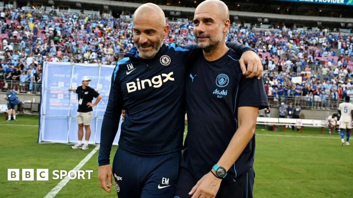 Two coaches embracing on the pitch after match