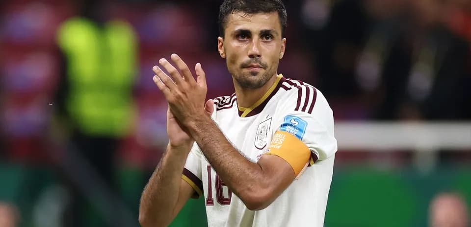 Player applauding fans after match wearing captain's armband