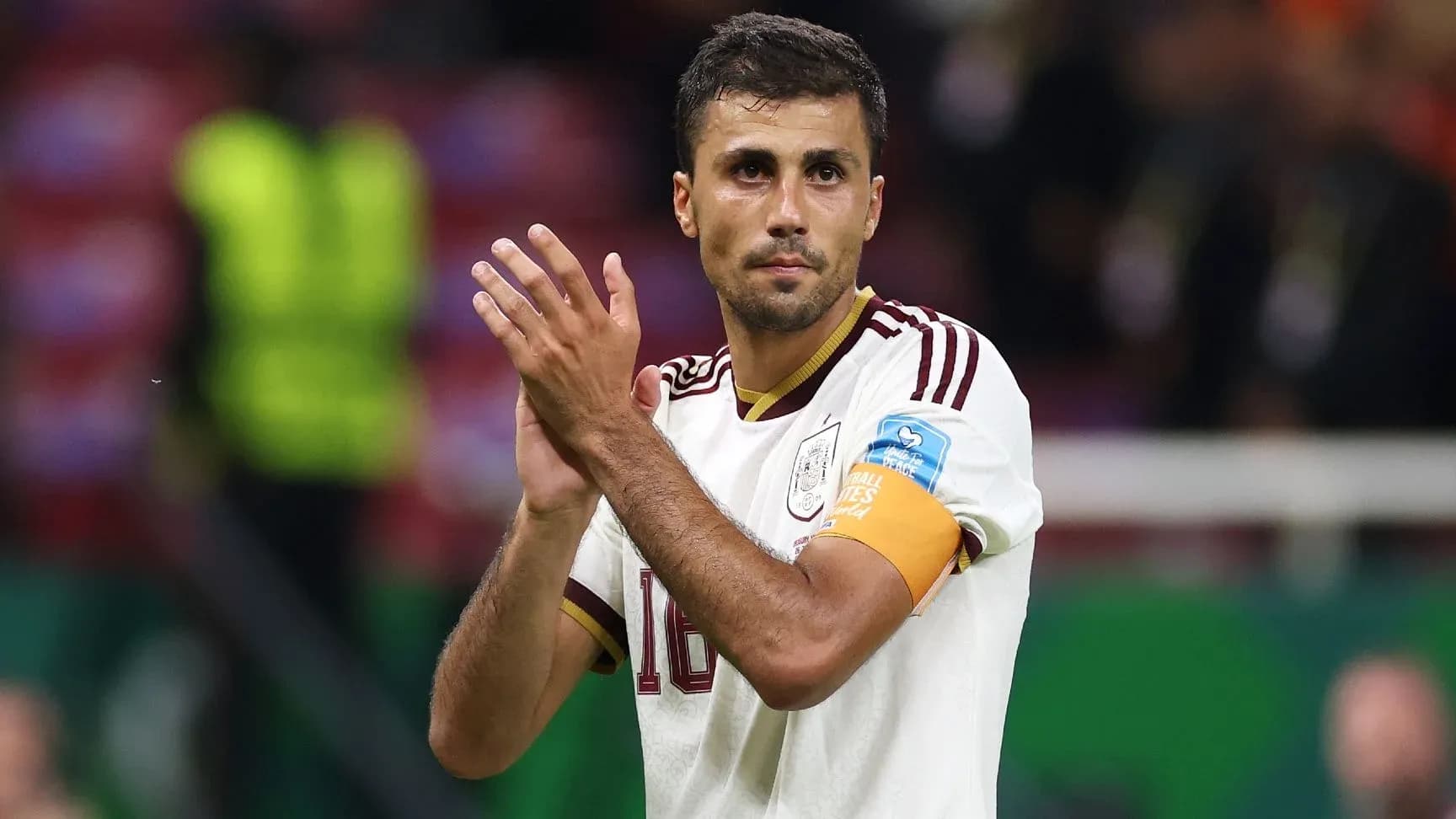 Player applauding fans after match wearing captain's armband