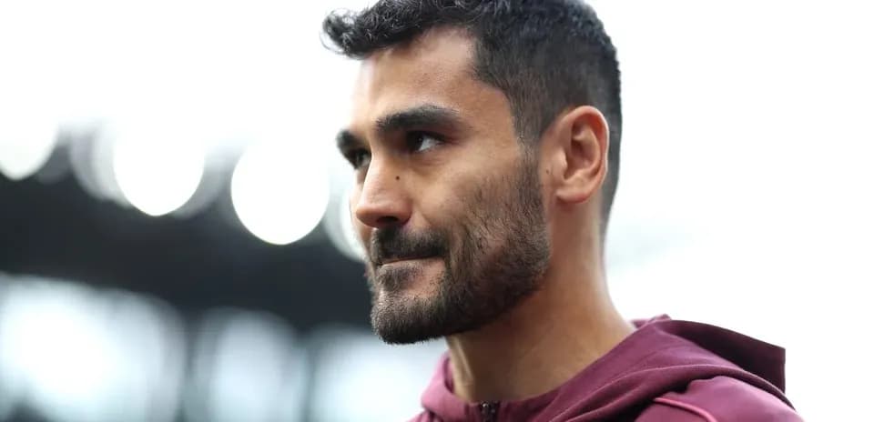 Player in maroon hoodie at stadium entrance