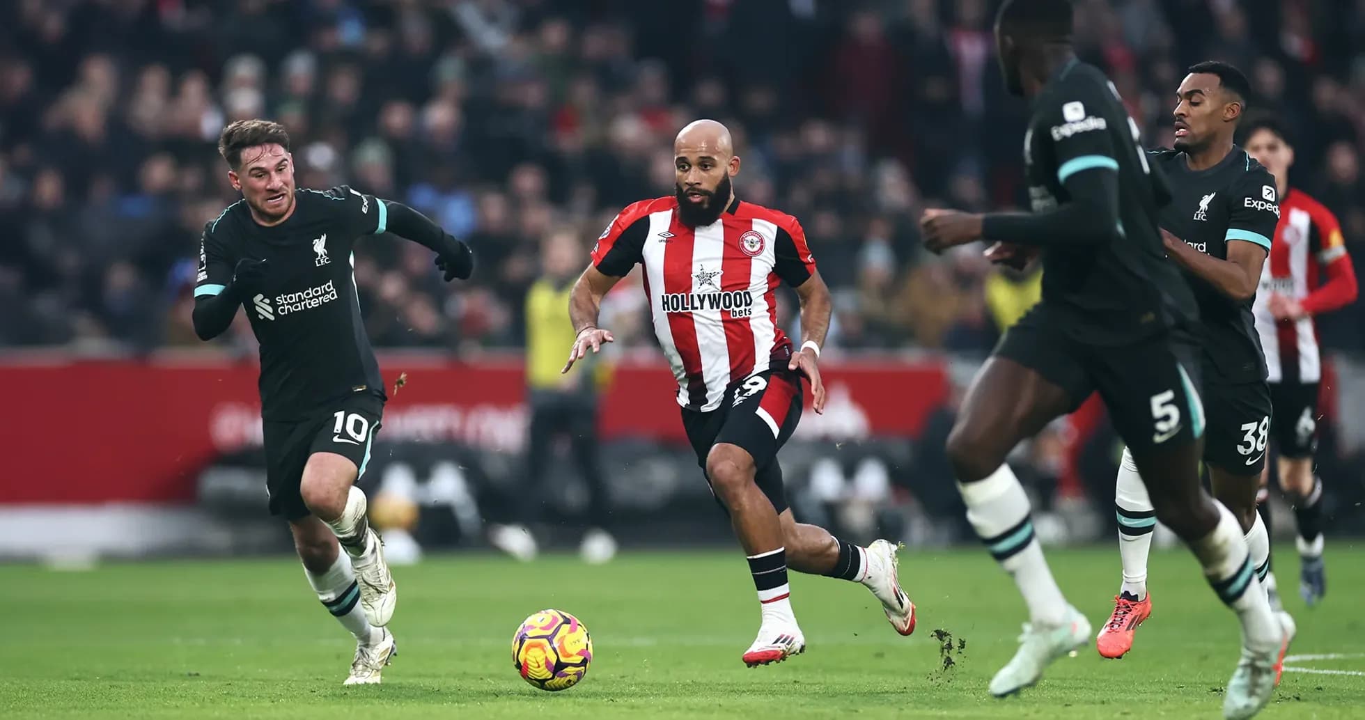 Liverpool player chasing Brentford opponent with ball