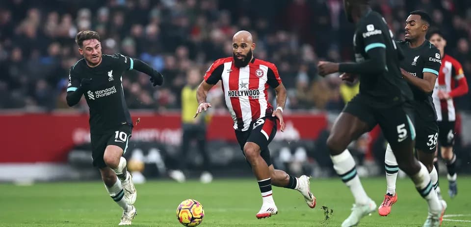 Liverpool player chasing Brentford opponent with ball