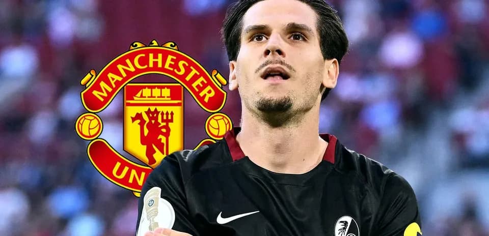 Player in black kit with Manchester United logo behind