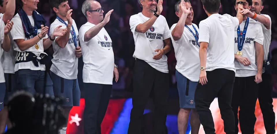 Coaches and staff celebrating with medals and t-shirts
