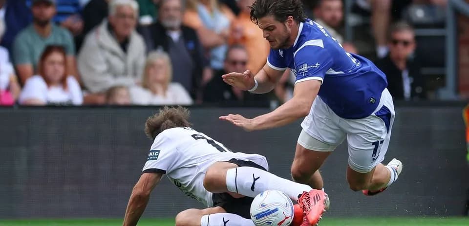 Player tackling opponent during football match action