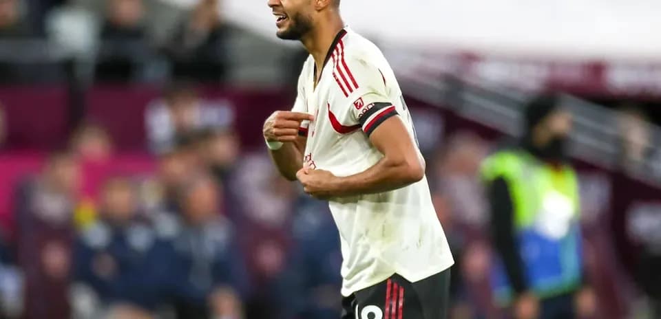 Player reacting during match, wearing red and white kit