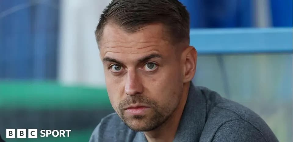 Man sitting in sports venue looking at camera