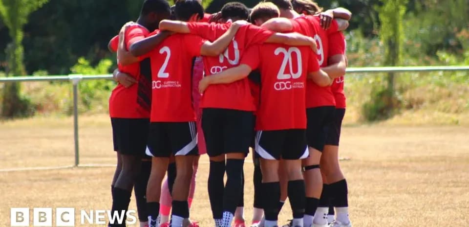 Team huddling together in red jerseys on field