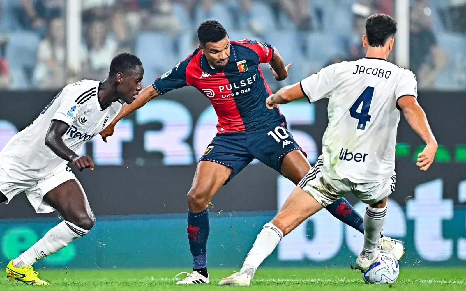 Genoa player dribbling against Como defenders