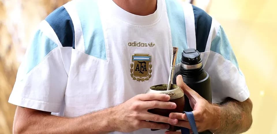 Player holding a mate cup and water bottle