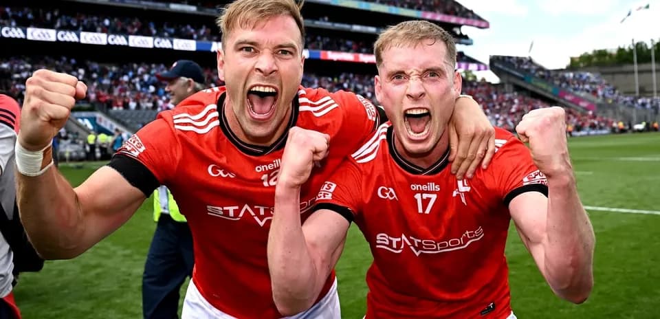 Two players celebrating in red jerseys on field
