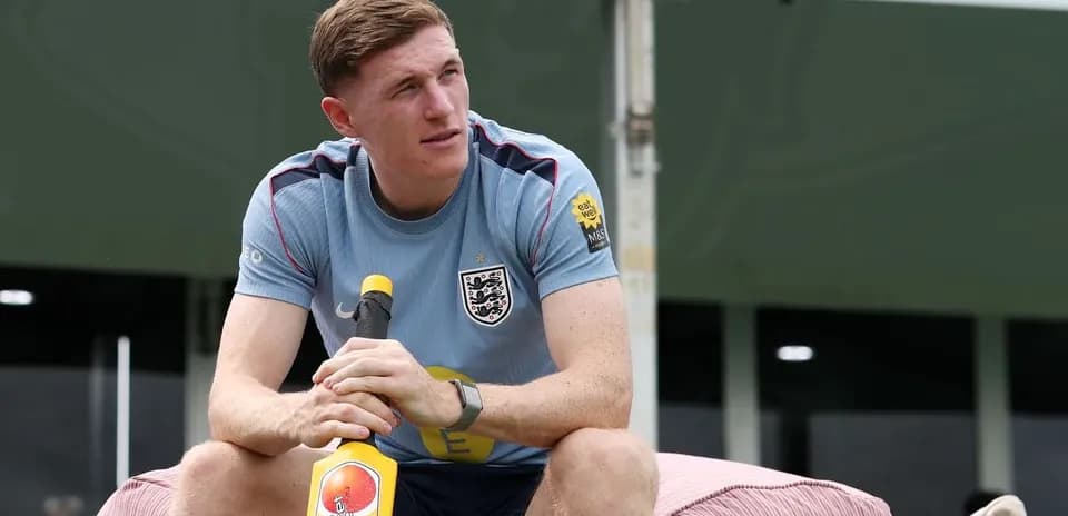 Player sitting on a bench holding a cricket bat