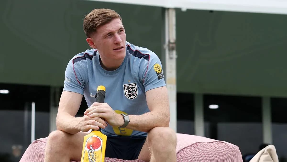 Player sitting on a bench holding a cricket bat
