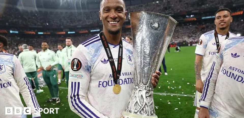 Player holding UEFA trophy with teammates celebrating